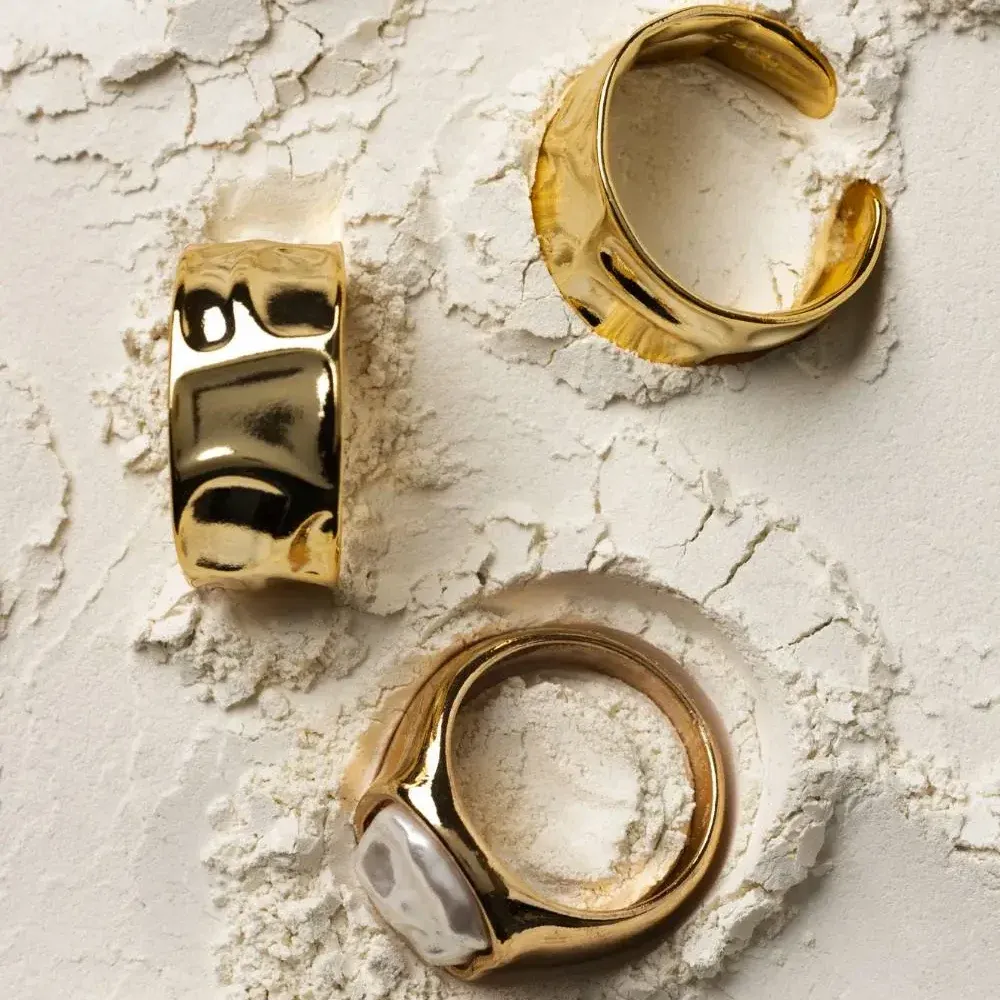 Expensive gold plating stainless steel ring with white powder background Expensive gold plating stainless steel ring with white powder background