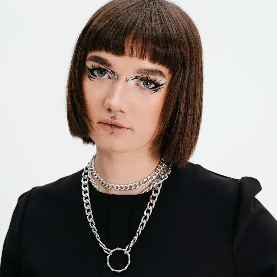 Medium shot goth teenager posing in studio wear stainless steel jewelry