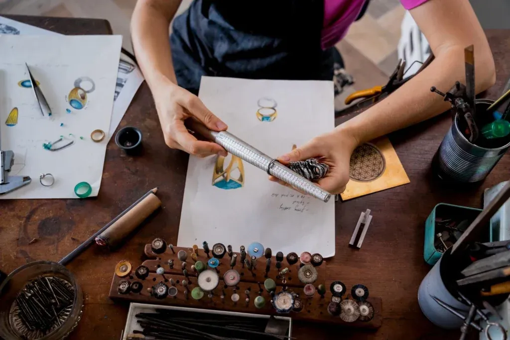 Young female jeweler making jewelry in workshop
