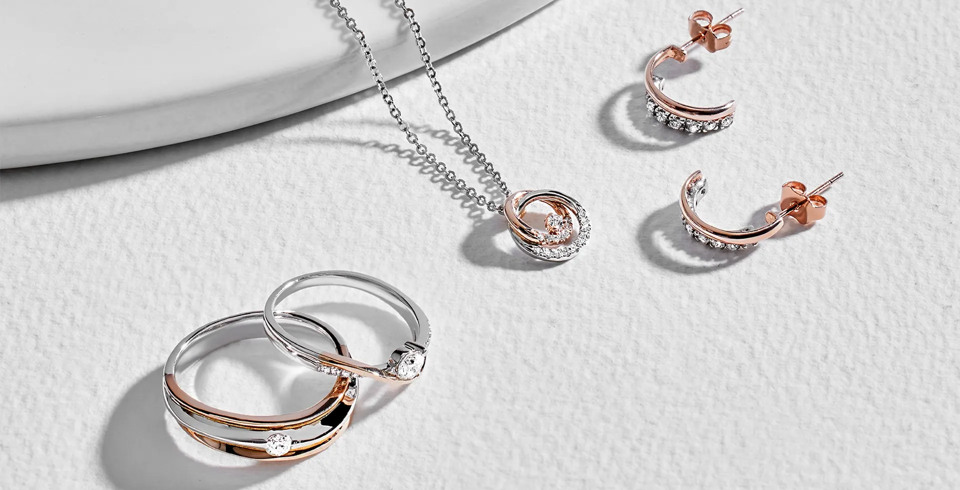 A selection of mixed metal jewelry including a silver and rose gold ring set crescent moon stud A selection of mixed metal jewelry including a silver and rose gold ring set crescent moon stud