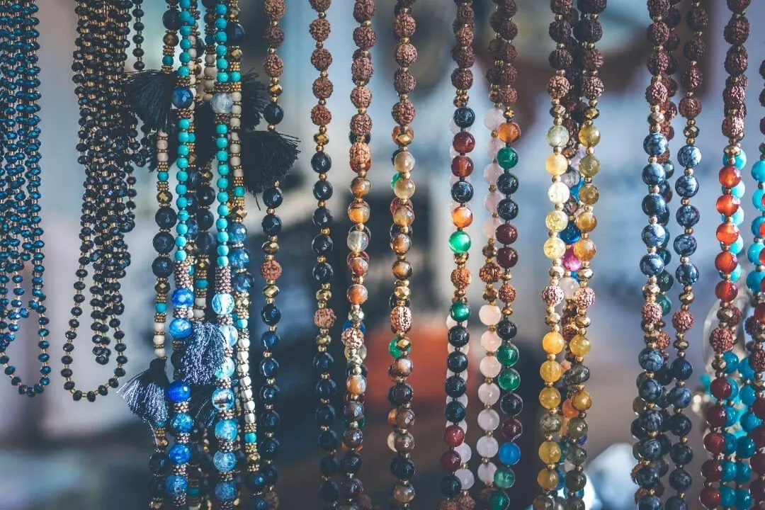 Colorful beaded necklaces with a mix of blues, reds, and browns displayed in a row Colorful beaded necklaces with a mix of blues, reds, and browns displayed in a row