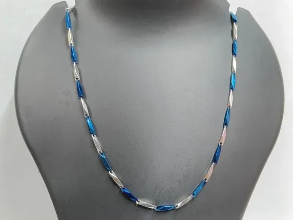 A blue and silver chain necklace displayed on a black mannequin bust A blue and silver chain necklace displayed on a black mannequin bust