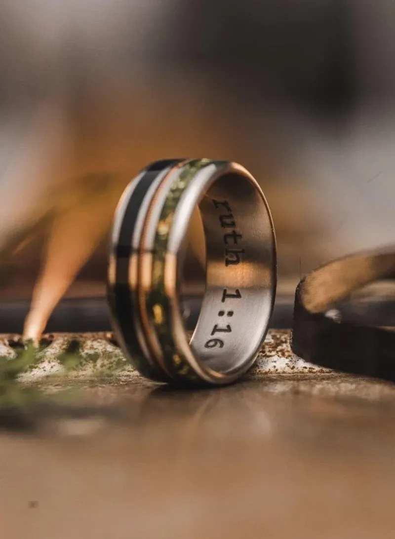 A close up of a metal ring with a black and gold inlay A close up of a metal ring with a black and gold inlay