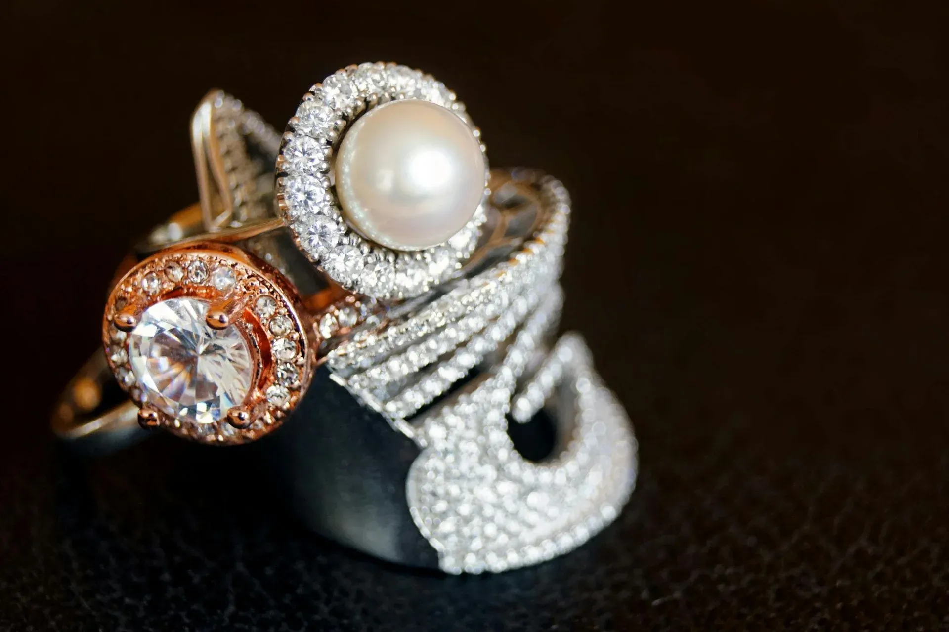 A collection of elegant rings featuring diamonds, a pearl, and intricate designs