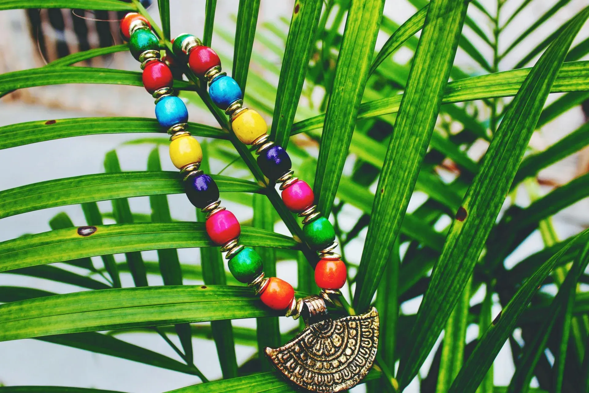 A colorful beaded necklace with a large decorative pendant