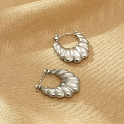 A pair of silver hoop earrings with a twisted design A pair of silver hoop earrings with a twisted design
