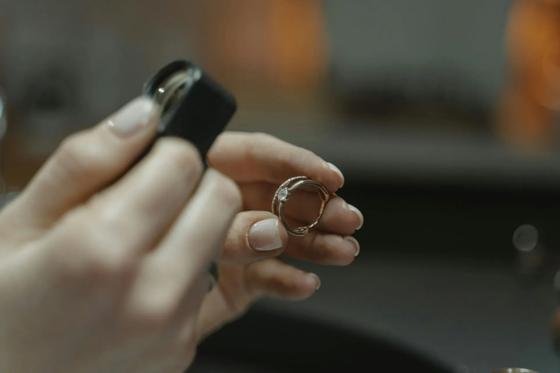 A person examining a ring with a magnifying loupe