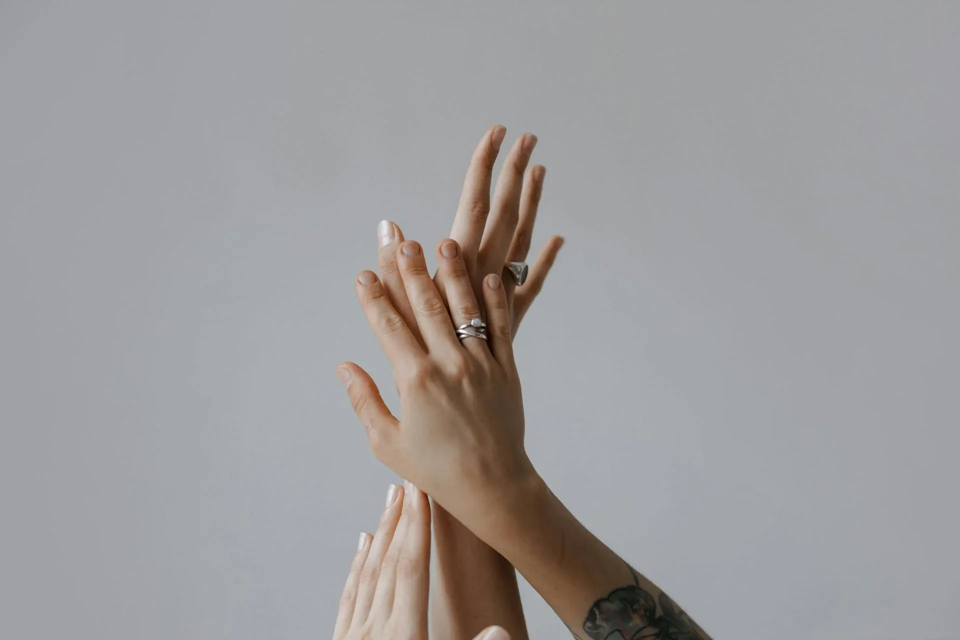 Several hands reaching upwards, adorned with rings Several hands reaching upwards, adorned with rings