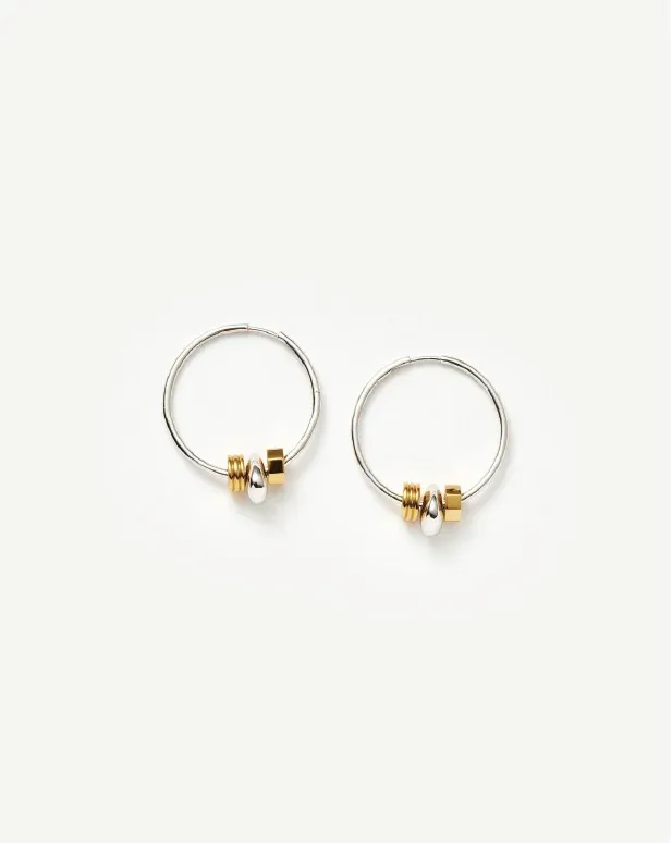 Silver hoop earrings with small gold and silver bead accents