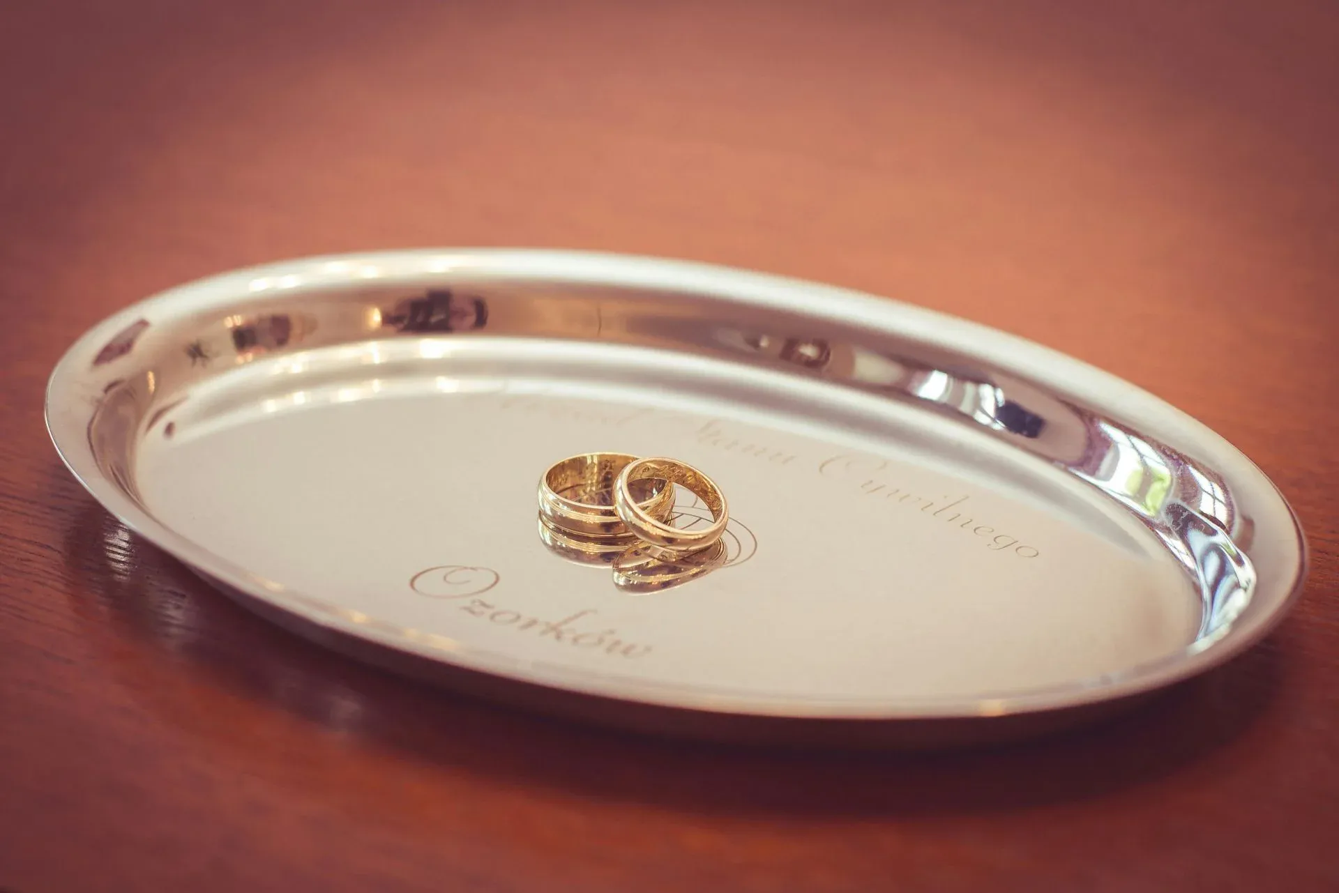 Two gold rings placed on a silver tray with engraved text Two gold rings placed on a silver tray with engraved text