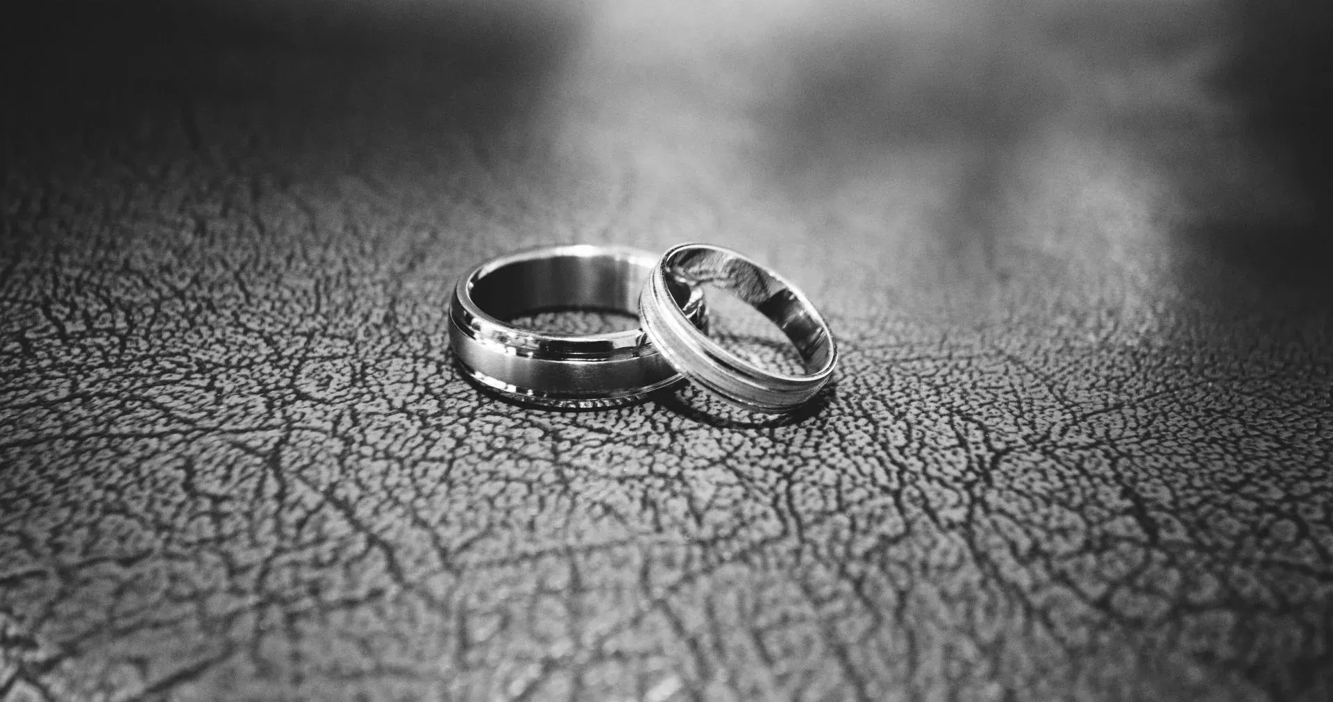 Two rings placed side by side on a textured dark surface Two rings placed side by side on a textured dark surface