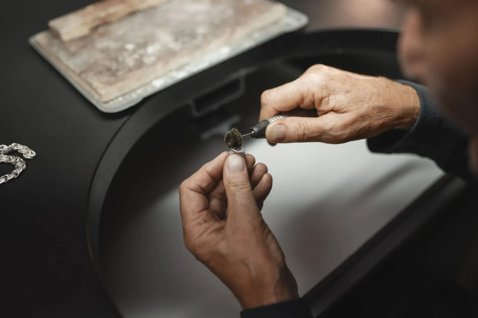 a jeweler at work polishing a ring in a workshop