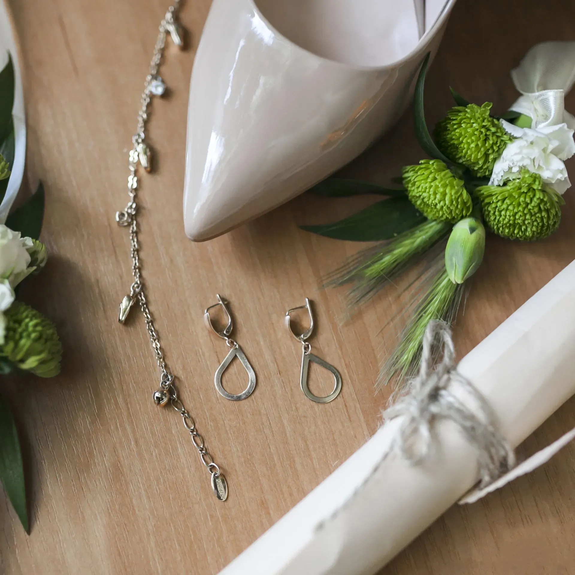 bridal accessories including earrings, a charm bracelet flowers and a high heeled shoe bridal accessories including earrings, a charm bracelet flowers and a high heeled shoe