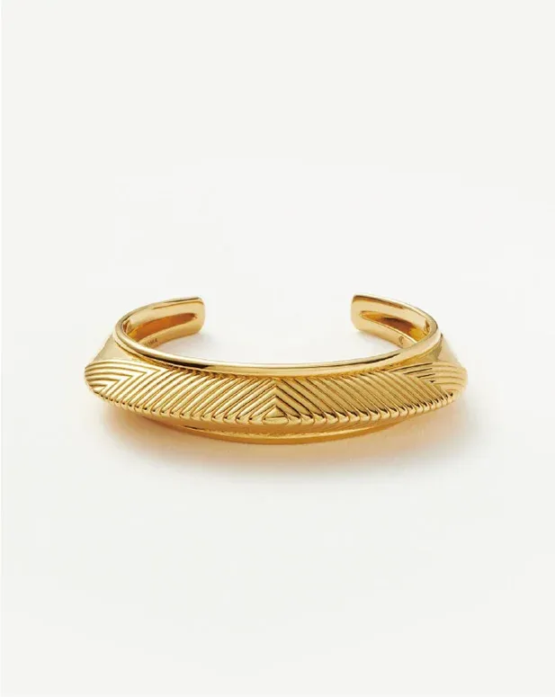 gold cuff bracelet with an engraved chevron pattern