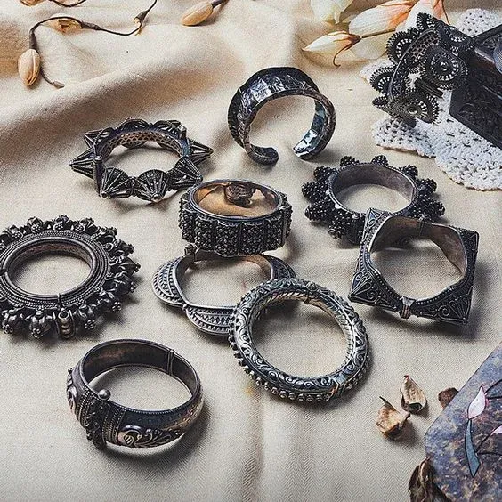 Collection of ornate bracelets arranged on a fabric surface Collection of ornate bracelets arranged on a fabric surface