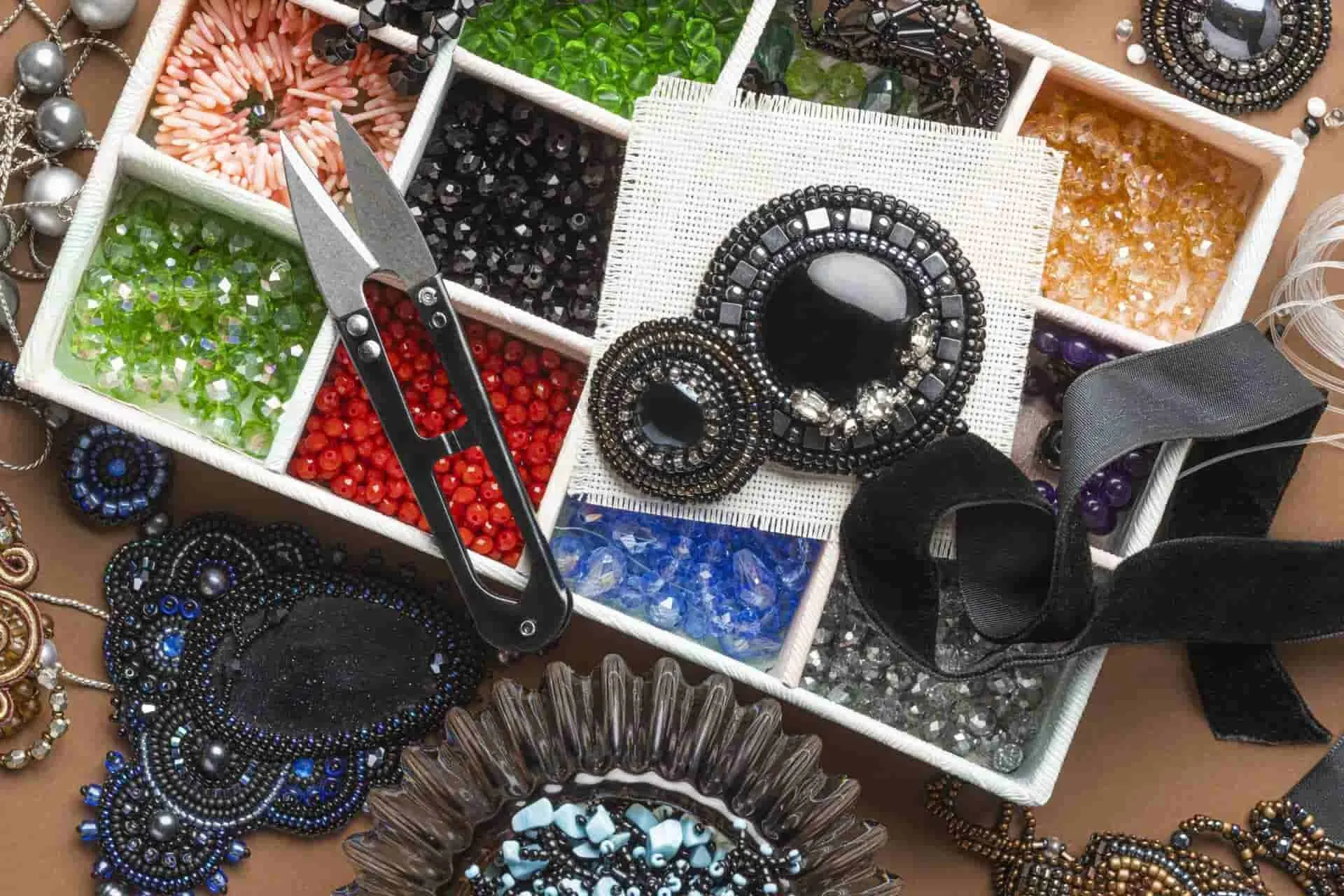 Flat lay of colorful beads, thread snips, ribbon, and beaded jewelry pieces Flat lay of colorful beads, thread snips, ribbon, and beaded jewelry pieces