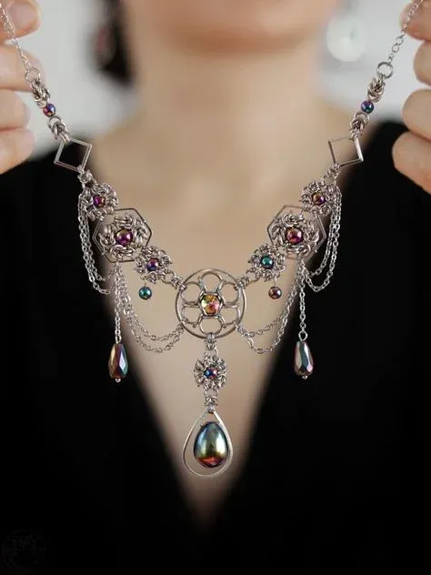 Ornate silver necklace with colorful gemstones and teardrop pendants