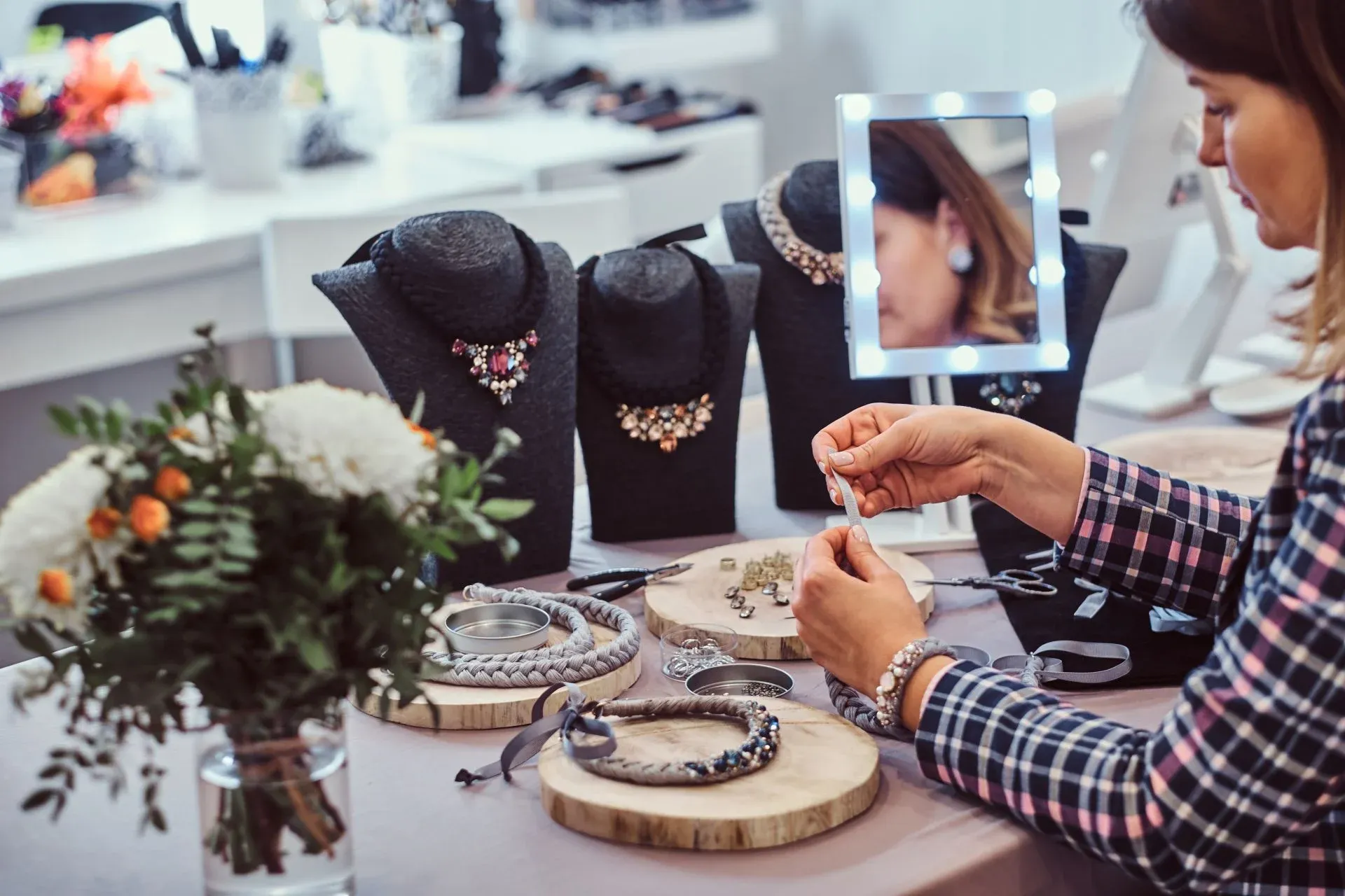 Woman crafting handmade necklaces at a jewelry workshop, with tools and displays Woman crafting handmade necklaces at a jewelry workshop, with tools and displays