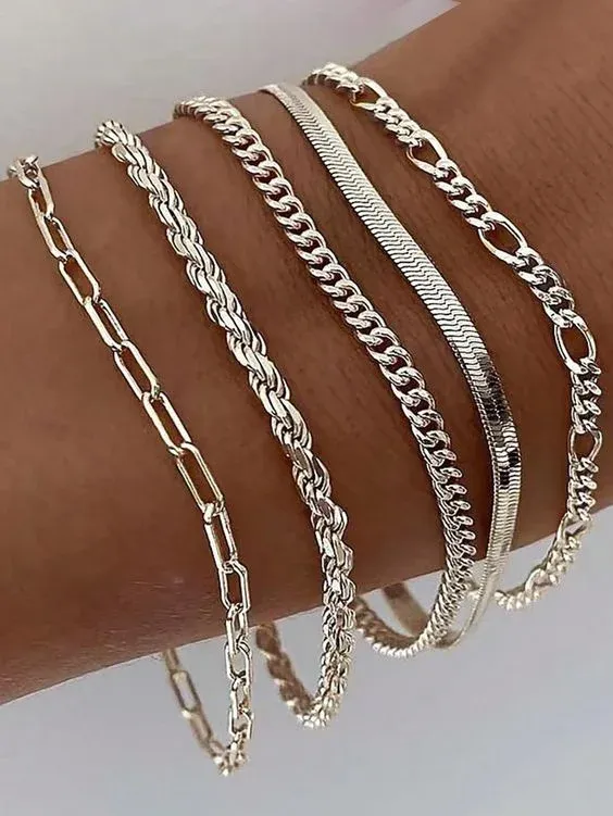 Wrist adorned with multiple styles of silver chain bracelets Wrist adorned with multiple styles of silver chain bracelets