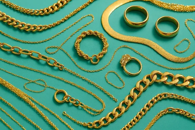 Various gold jewelry pieces arranged artistically on a turquoise background Various gold jewelry pieces arranged artistically on a turquoise background