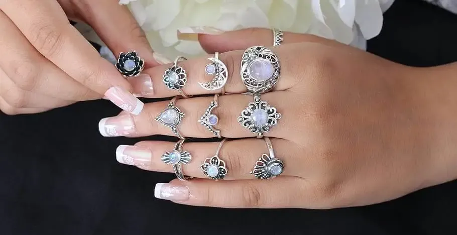 Hand with manicured nails wearing ornate silver and gemstone rings Hand with manicured nails wearing ornate silver and gemstone rings