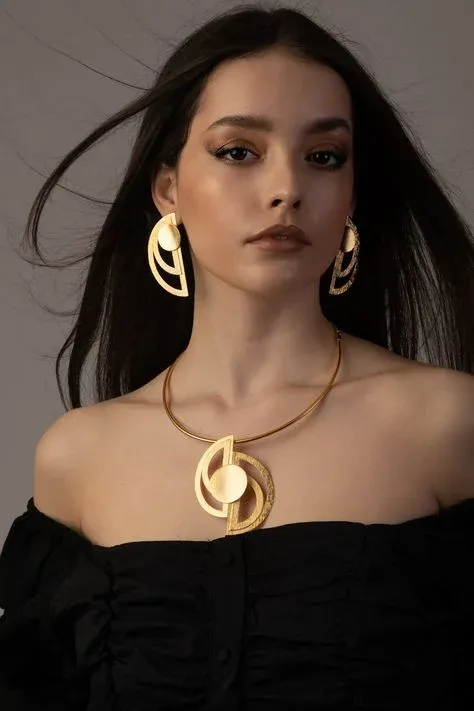 Woman with gold geometric earrings and matching necklace