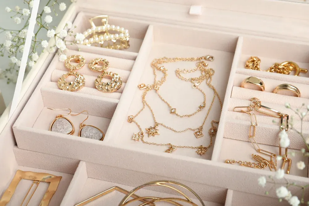 Jewelry box with organized gold earrings, necklaces, and bracelets