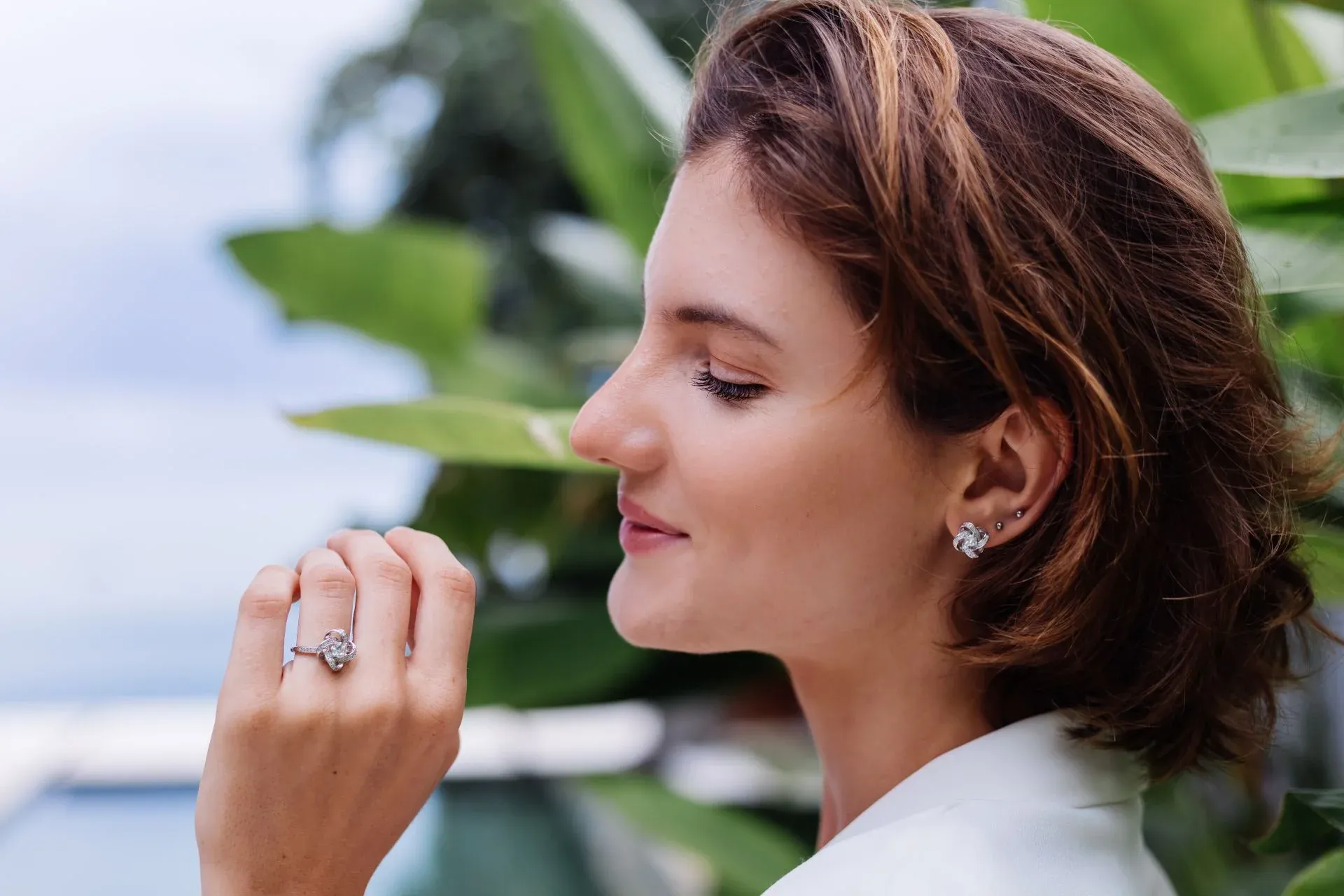 Woman wearing a diamond ring and earrings, outdoors