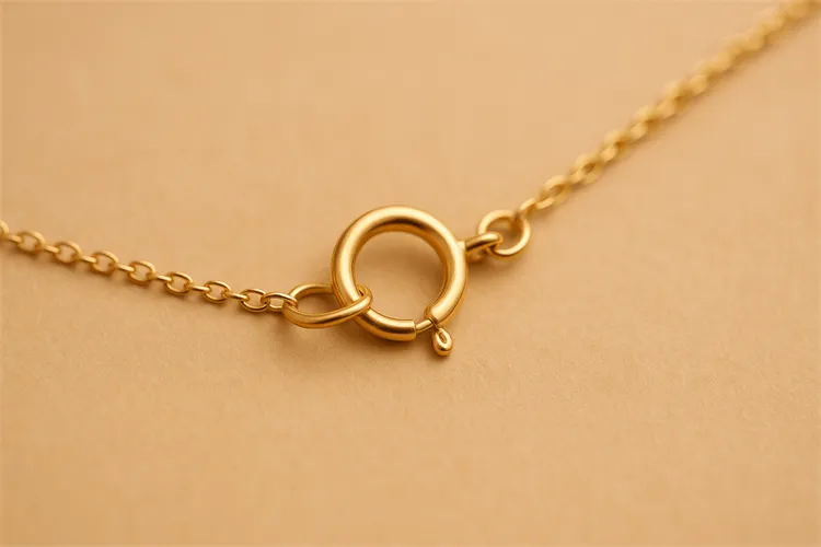 Gold spring ring clasp on a delicate necklace. Gold spring ring clasp on a delicate necklace.