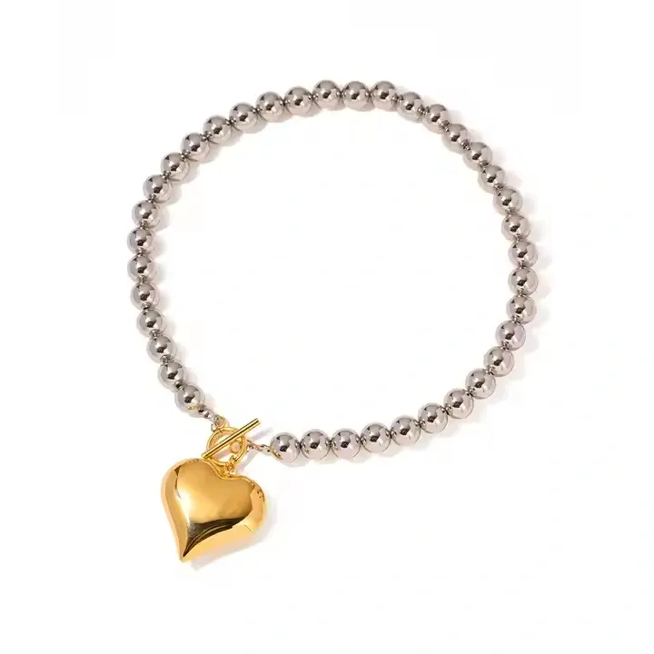 Stainless steel bracelet with gold heart charm and silver beads