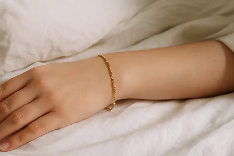 A hand with a welded bracelet rests on the pillow A hand with a welded bracelet rests on the pillow