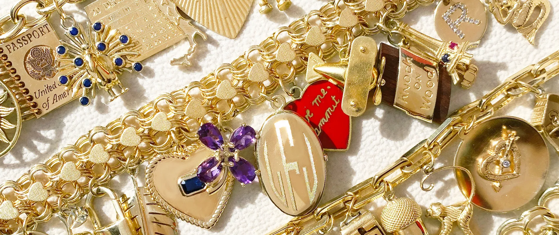 Charms Jewelry collection gold pendants, including heart, lock design and gemstone setting.