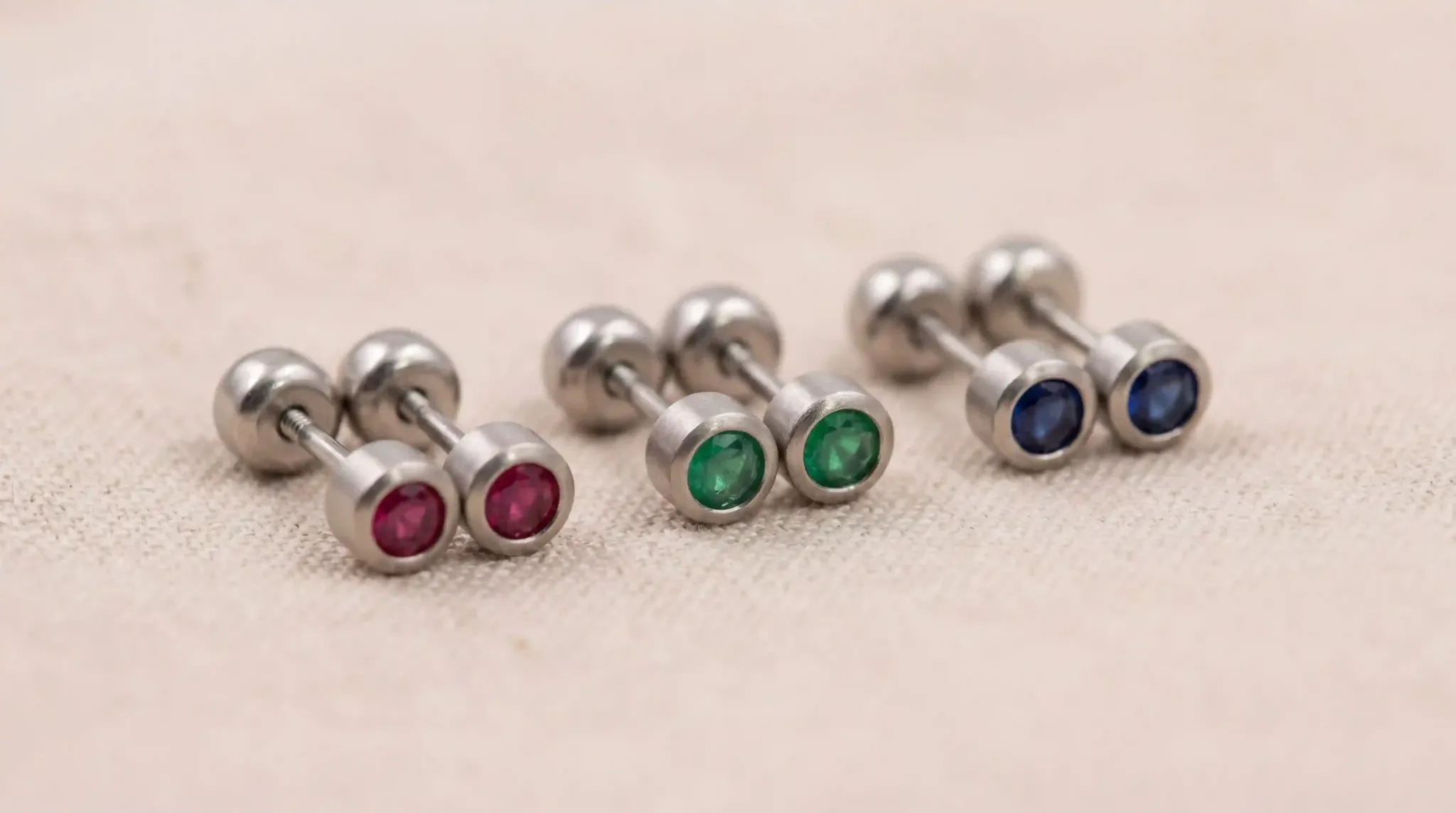 A pair of stainless steel birthstone stud earrings for children in a bright, safe setting