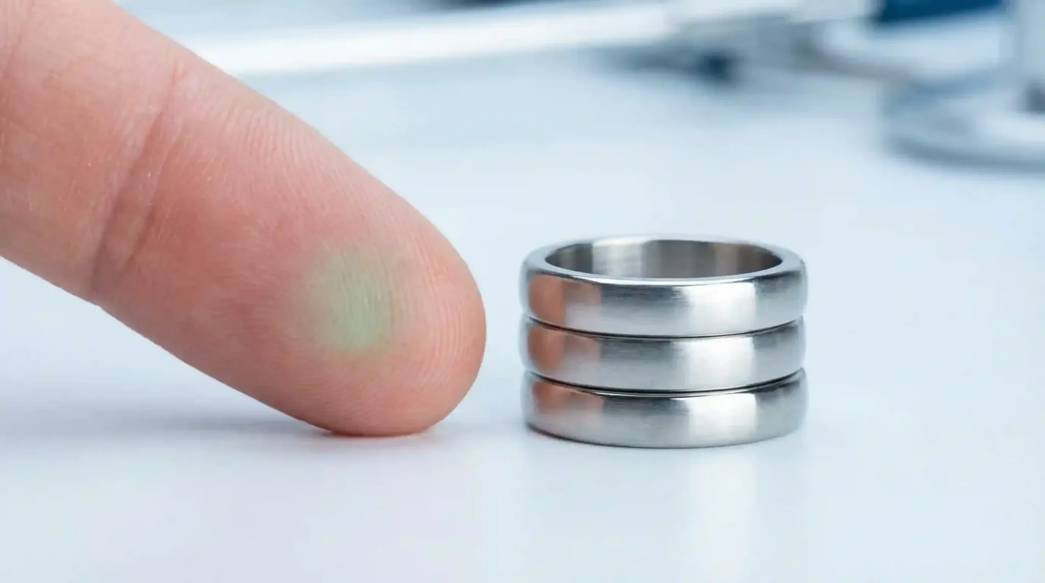 Comparison showing a finger with a green stain next to a stack of non-reactive rings